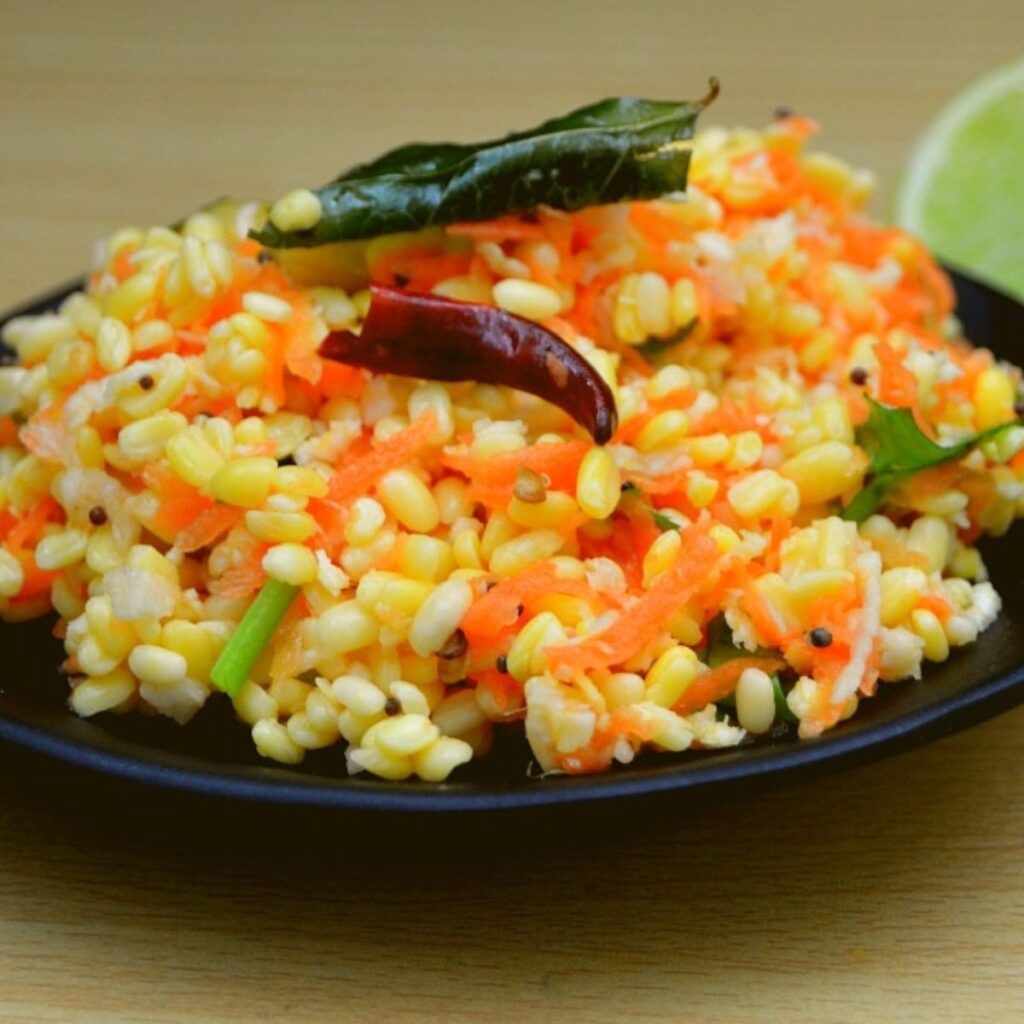 carrot kosambari in black plate with half lime on wood table