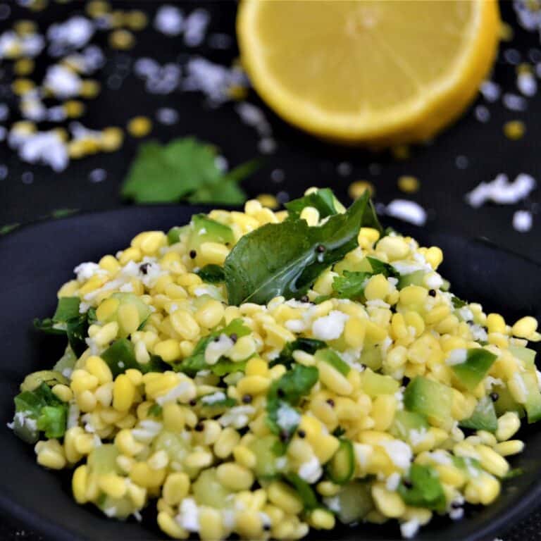 cucumber lentil salad placed on black table with a cut lemon.