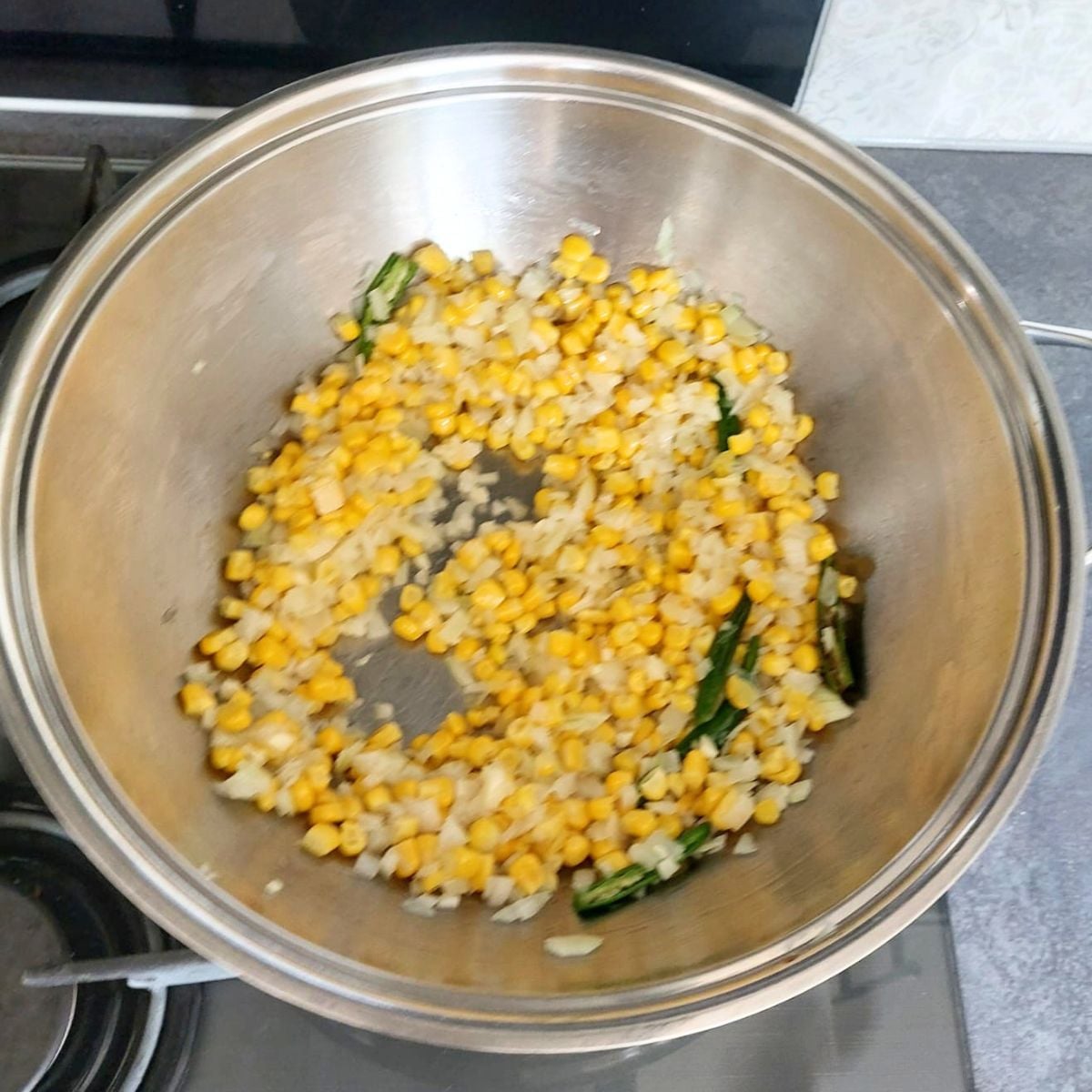 sauteing onion, sweetcorn in a wide steel pan