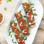 pin image of vegetable stuffed zucchini boats with black text overlay on the top.
