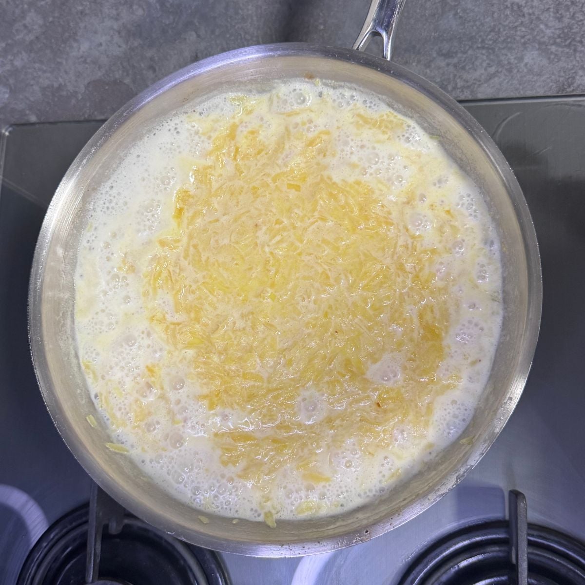 pumpkin halwa simmering with milk in steel pan