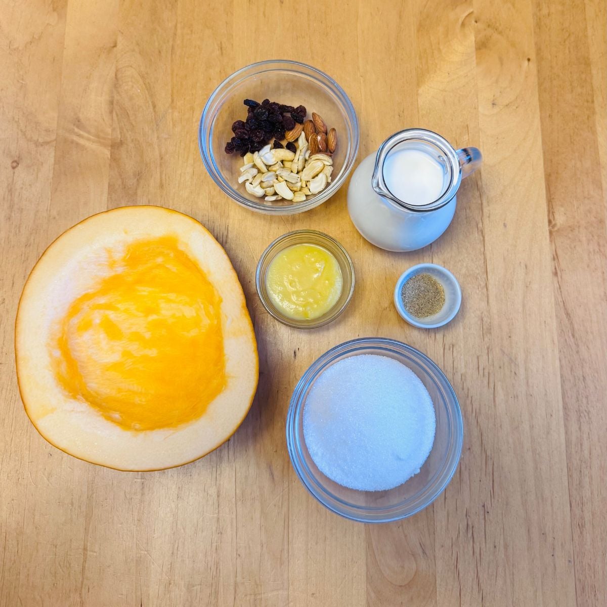 Ingredients to make pumpkin halwa on wooden table.