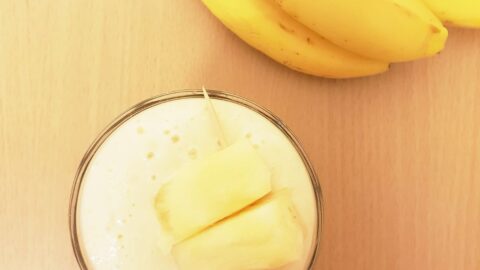 glass of smoothie and banana on table