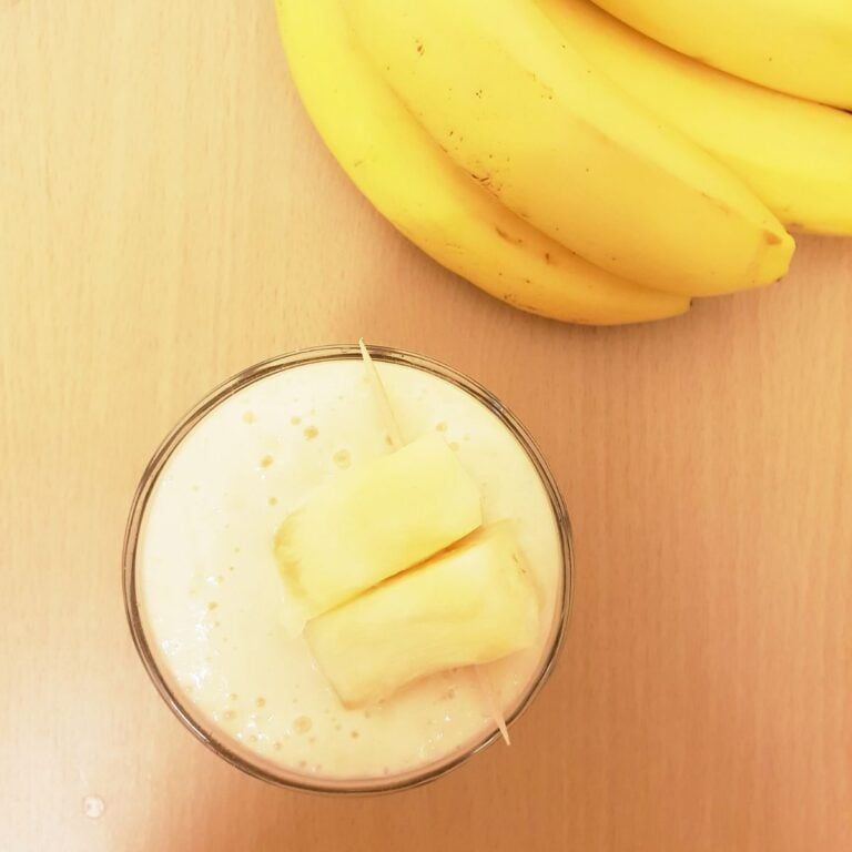 glass of smoothie and banana on table
