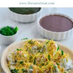 pin image with green text overlay on top showing papdi chaat arranged in a wooden plate placed on marble along with green and tamarind chutney.
