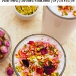 pin image of rose lassi topped with nuts and dried rose petals with black text overlay on top.