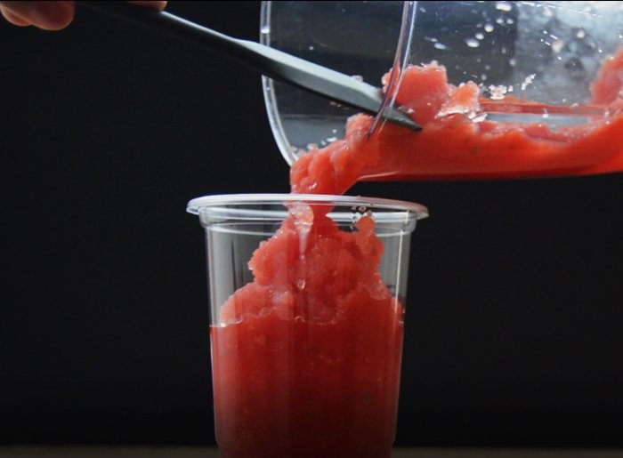 pouring watermelon slushie in a glass