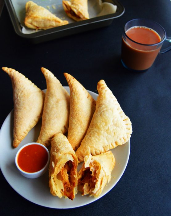curry puffs with dipping sauce in a plate.