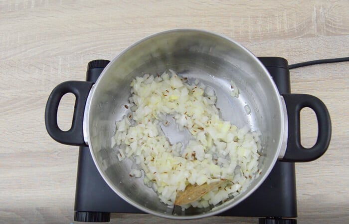 saute onions, ginger-garlic paste with cumin in a steel pot.