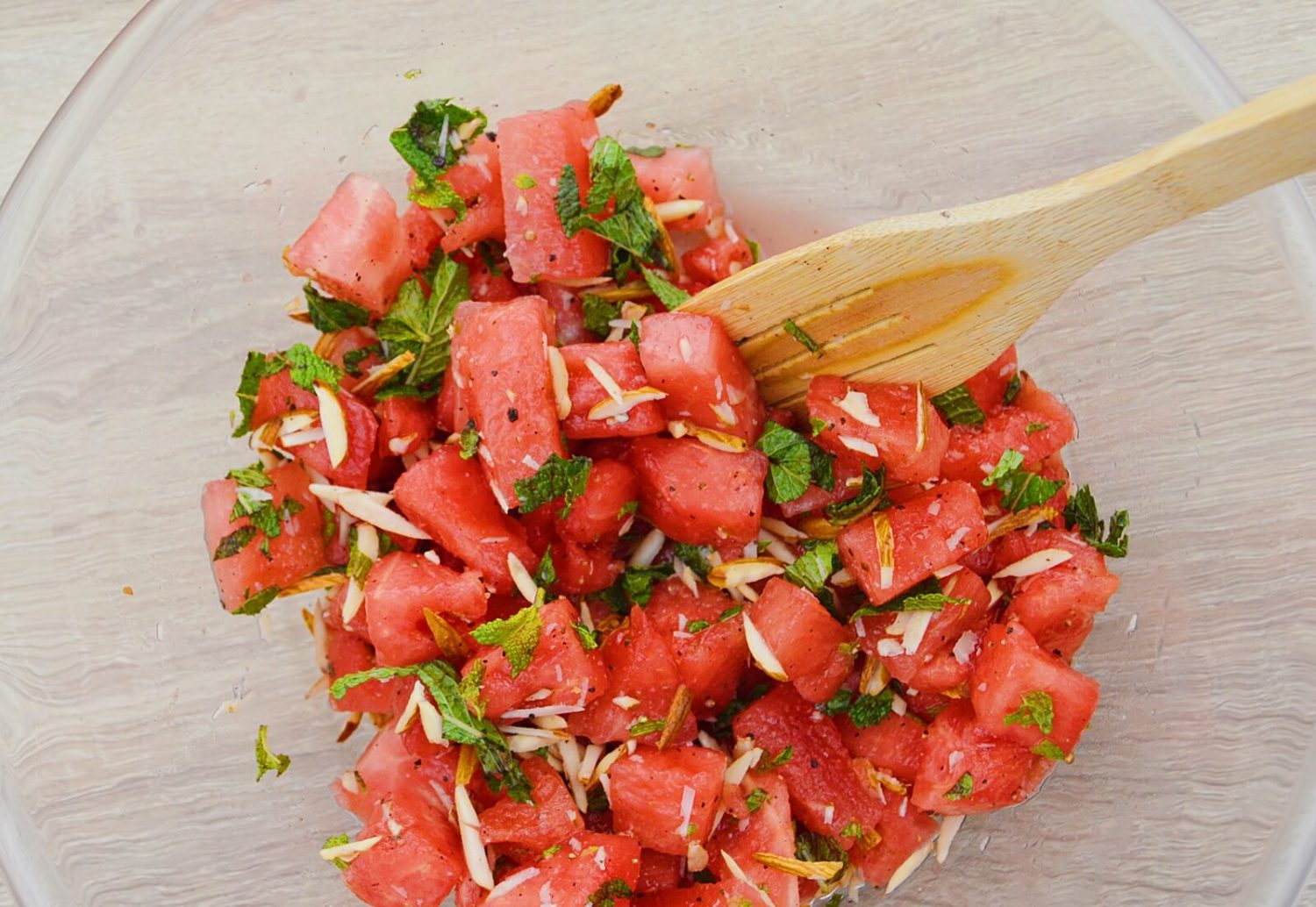 combining all ingredients to make watermelon salad.