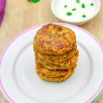 pin image of stack of chickpea veggie patties on 2 side plates on a granite with a bowl of yogurt dip behind it and text overlay on top and bottom.