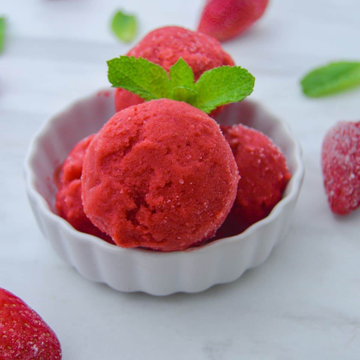 Strawberry frozen yogurt in glass bowl, ice cream balls, container