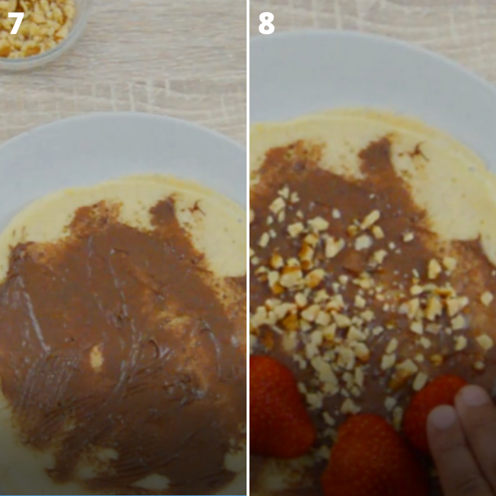 crepes filled with chocolate, nuts and strawberries in a grey plate on a table.