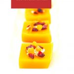 square mango pudding topped with dry fruits with text overlay on red background at the top.