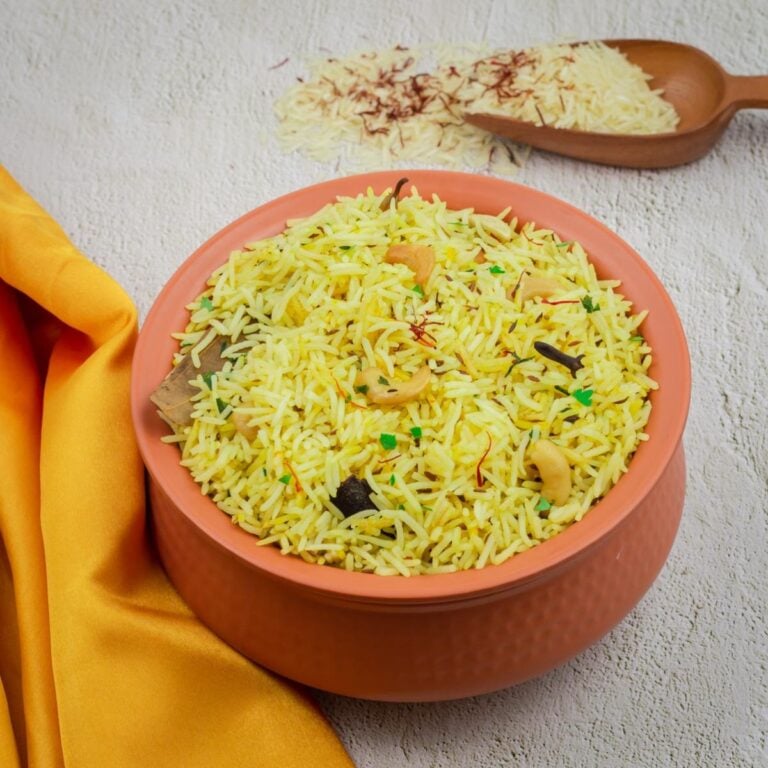 saffron rice in brown pot with orange cloth placed on a granite.