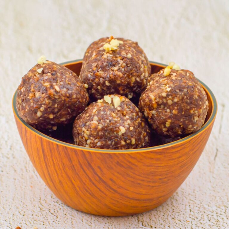 brown bowl of chocolate energy balls placed on a granite.