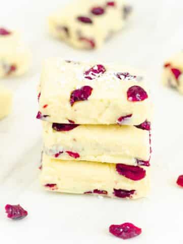 stack of 3 cranberry white chocolate fudges on a marble.