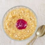 pin image of rice pudding in a glass bowl with pink text overlay on the top and bottom.