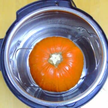 whole pumpkin inside the instant pot on the trivet ready to be cooked.