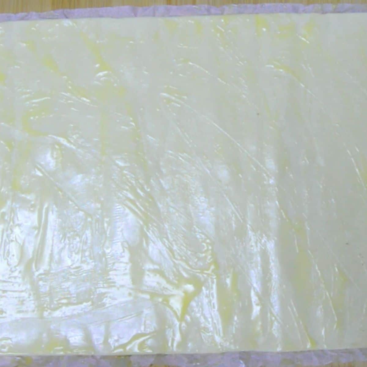 unrolled puff pastry sheet with butter applied all over.