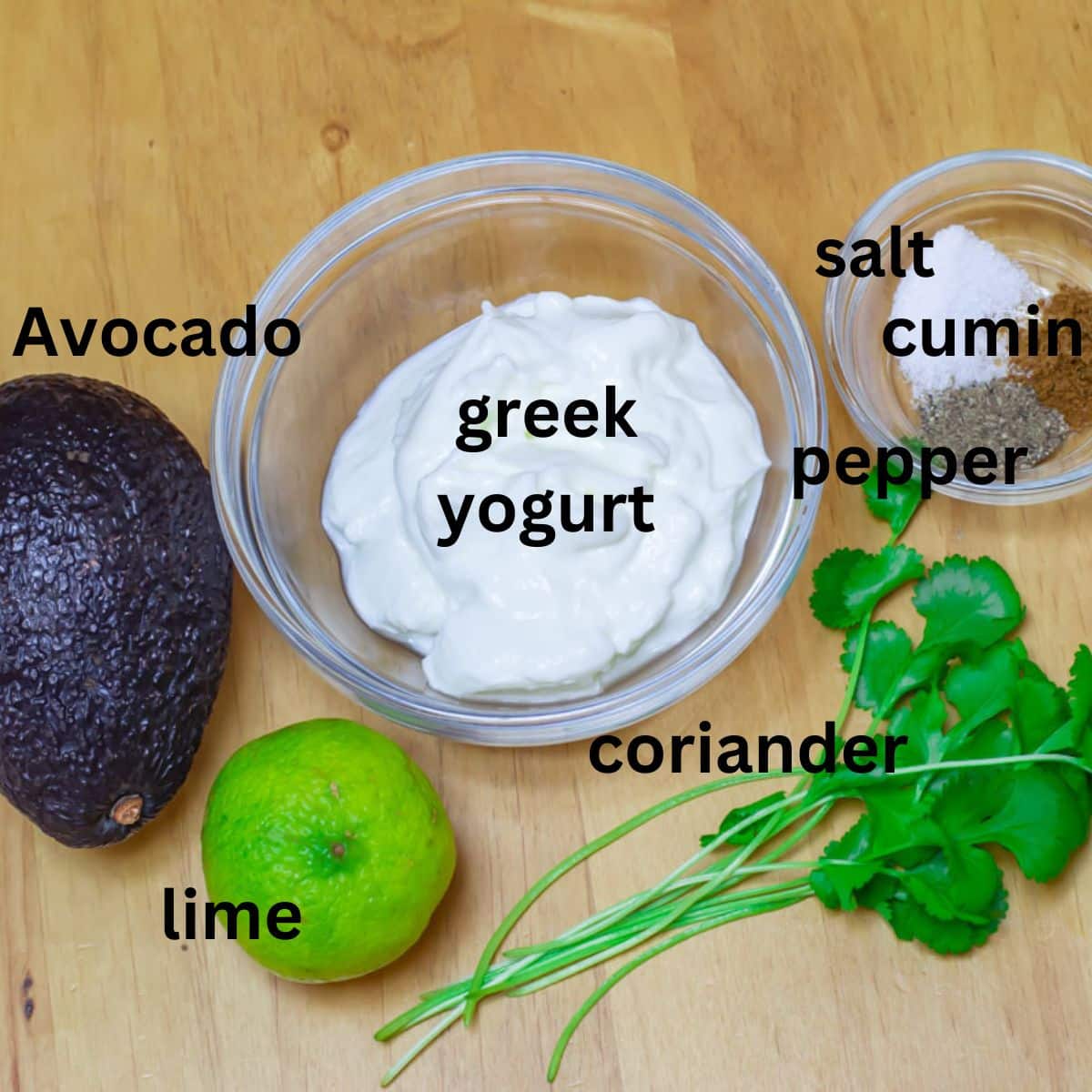 yogurt, coriander, avocado, lime and seasoning placed on a wooden table.