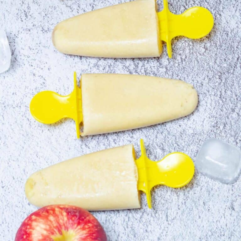 3 popsicles with apple and ice cubes placed on the tile.