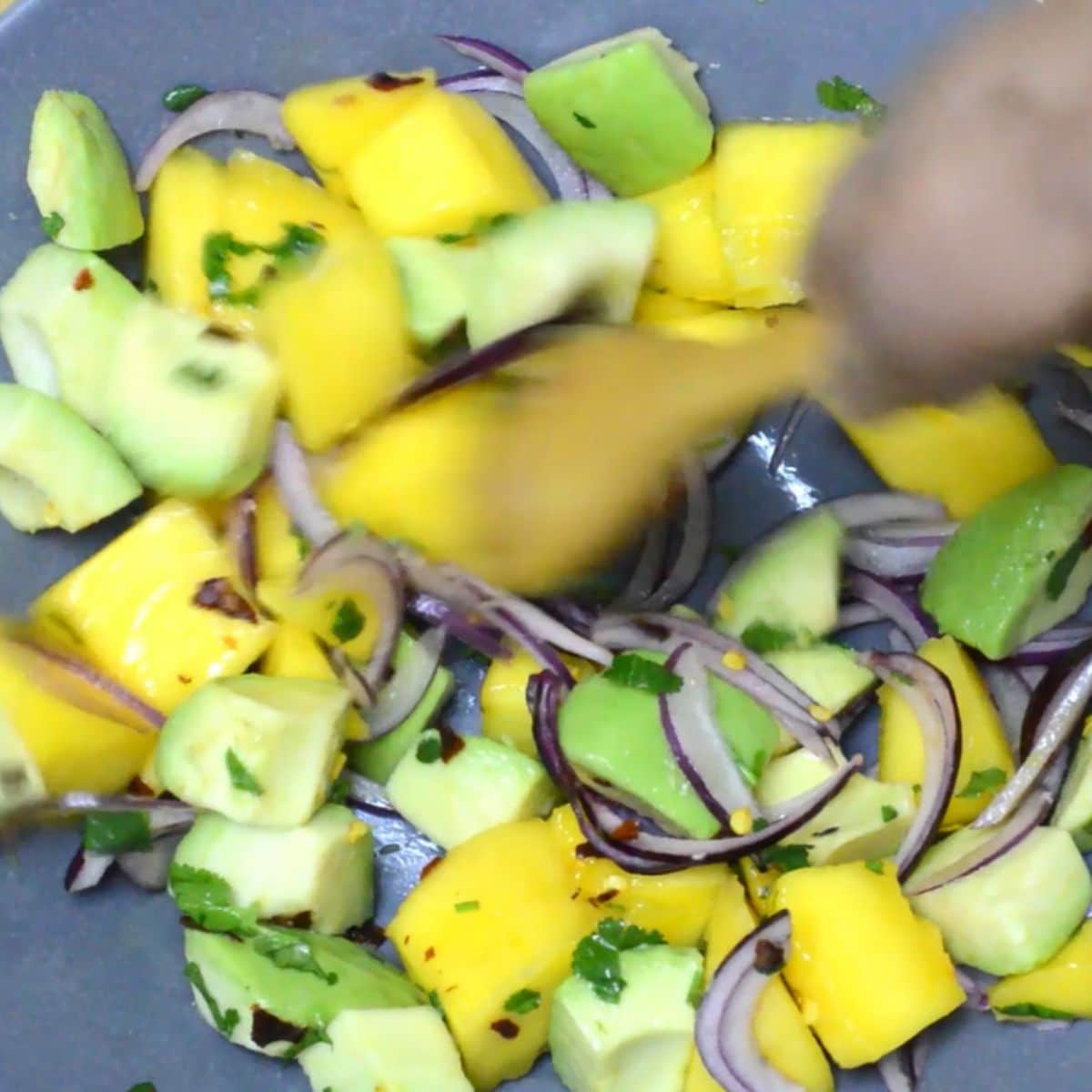 mixing salad with a wooden spoon