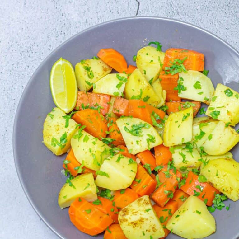 seasoned carrots and potatoes in a grey bowl.
