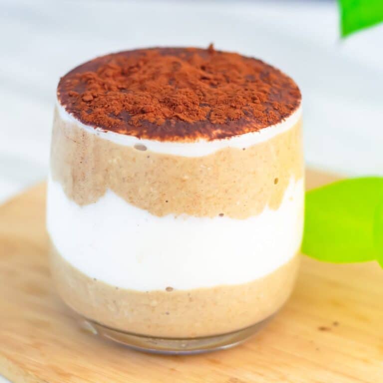 tiramisu overnight oats in a glass placed on wooden board.