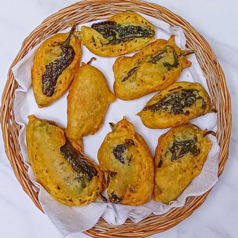 basket of mirchi bajjis placed on a marble.