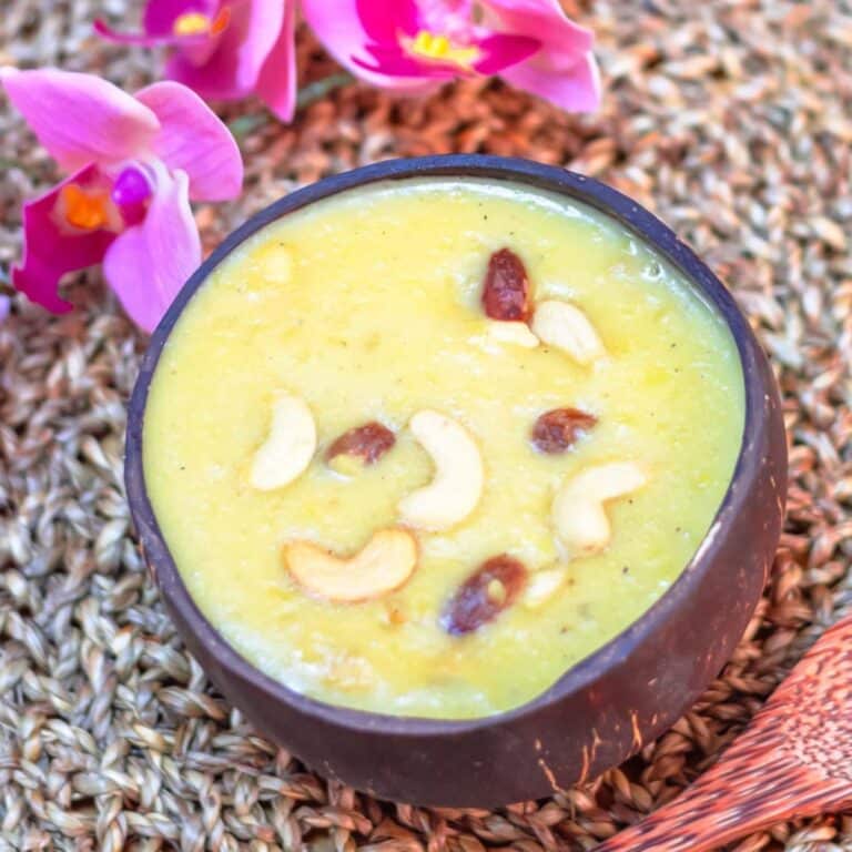 moong dl payasam in a coconut shell placed on a woven mat.