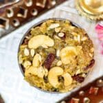 bowl of lauki halwa with cashews and raisins placed on a silver plate.