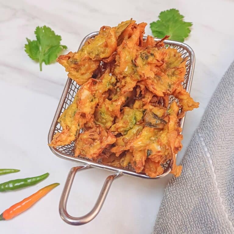 cabbage pakoda in a steel basket placed on marble.