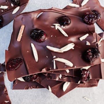 dark chocolate almond bark stacked on a greaseproof paper.
