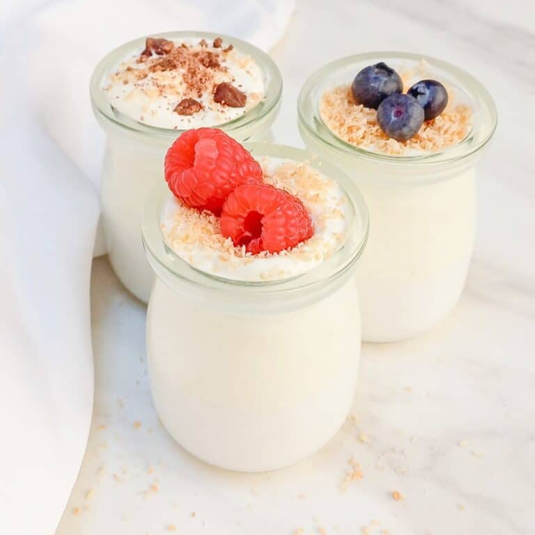 top view of 3 jars of mousse topped with fresh raspberries,blueberries and chocolate shavings.
