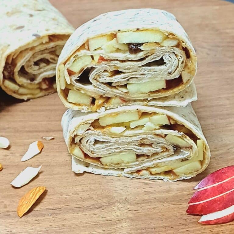 half cut apple tortilla wraps placed on wooden board.