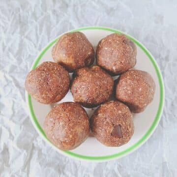 white plate with chocolate almond balls placed on baking sheet.