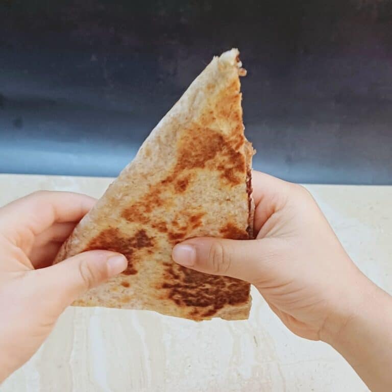 child holding chocolate banana quesadilla