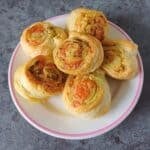 pesto pinwheels in a plate placed on black granite.