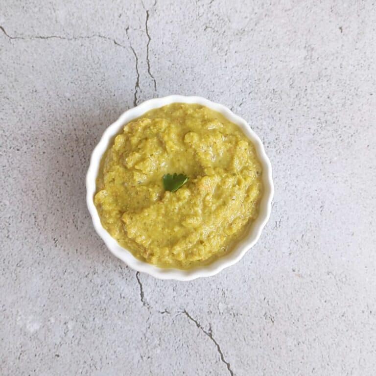 white bowl of beerakaya pachadi placed on a tile.