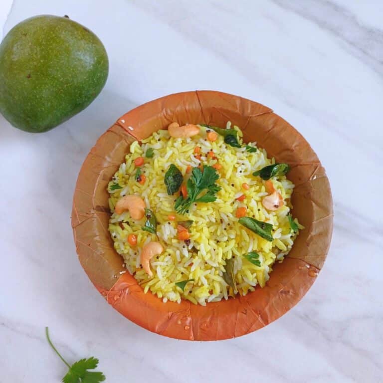 raw mango rice in a brown rice placed on a marble along with a raw mango.