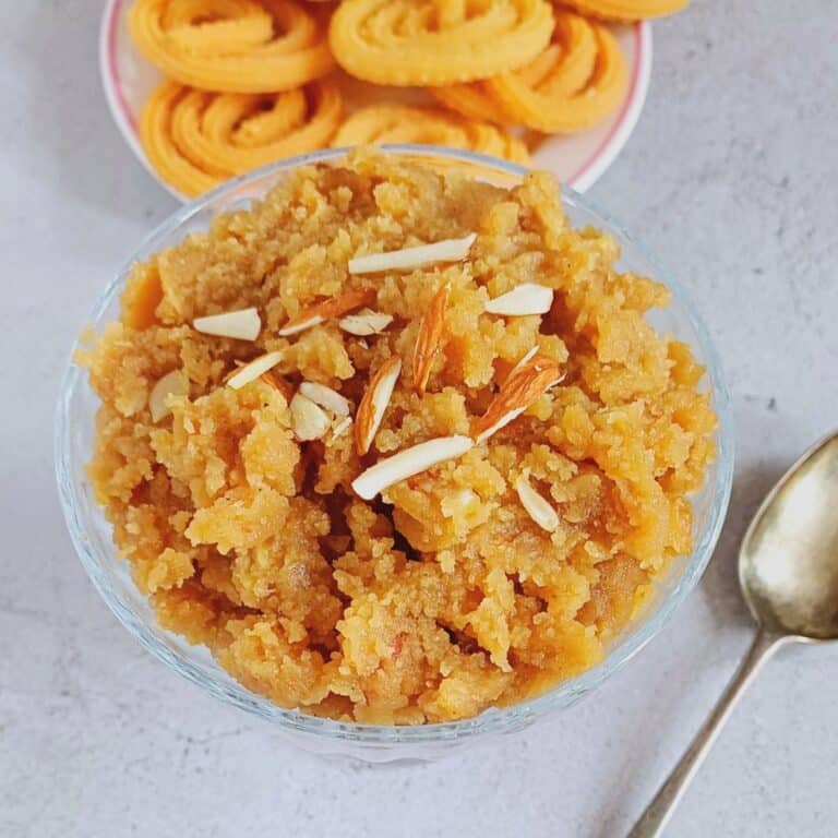 a bowl of ukkiri placed on tile along with a plate of murukku behind it.