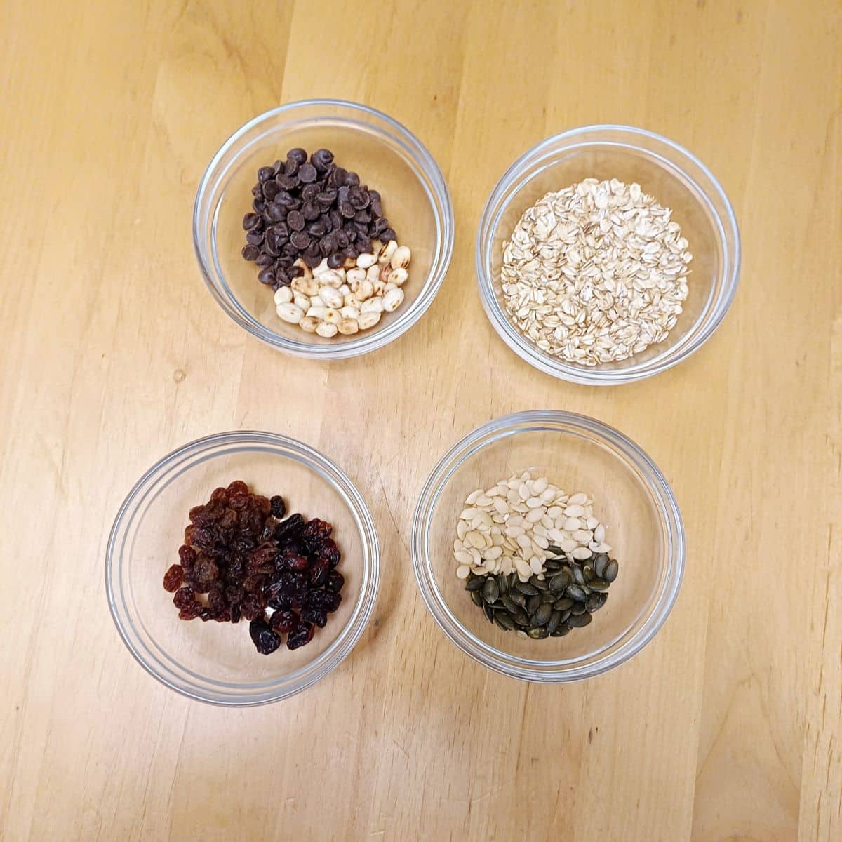 ingredients to prepare trail mix on wooden table.
