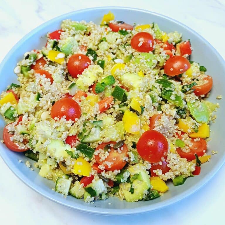 blue bowl of quinoa vegetable salad placed on marble.