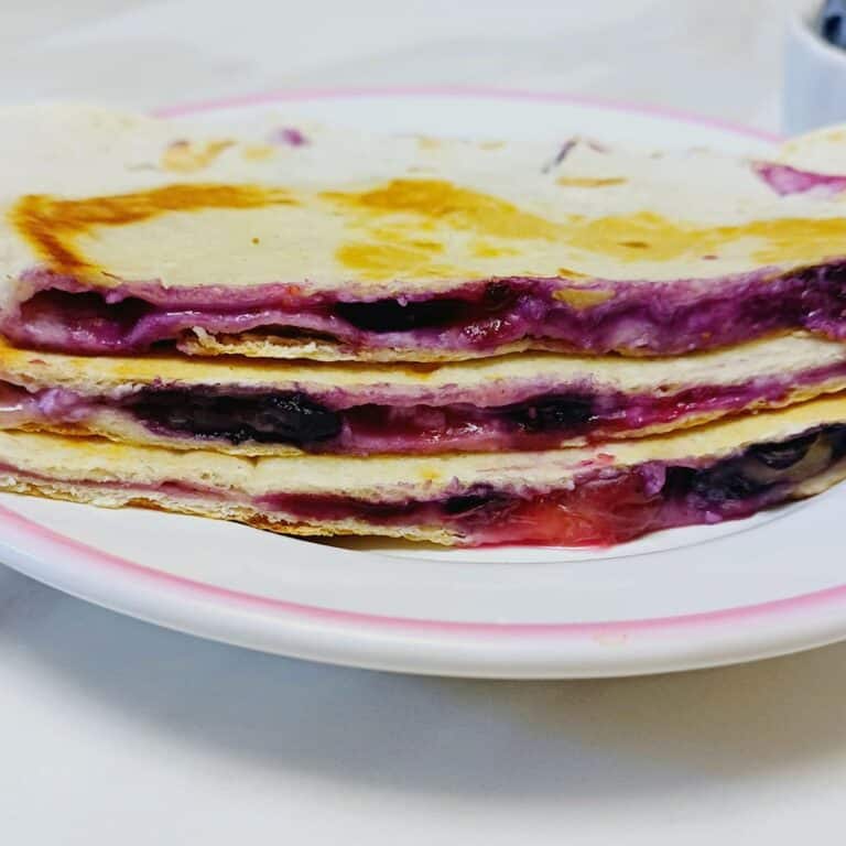 blueberry breakfast quesadilla stacked on a white plate.