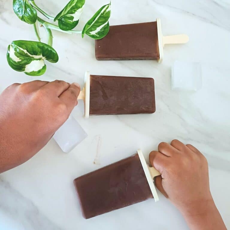 kids holding banana chocolate popsicles.