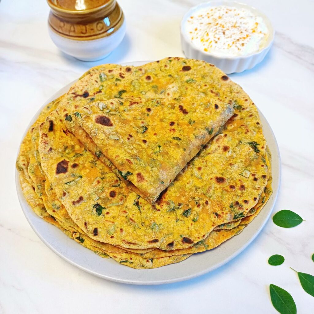 moringa leaves paratha stacked on a grey plate.