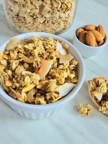 coconut shell filled with granola placed on a granite.