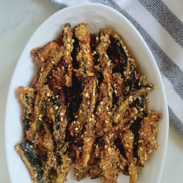 white plate of crispy baked zucchini sticks.
