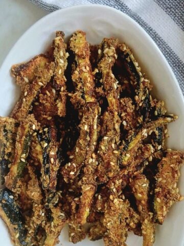 white plate of crispy baked zucchini sticks.